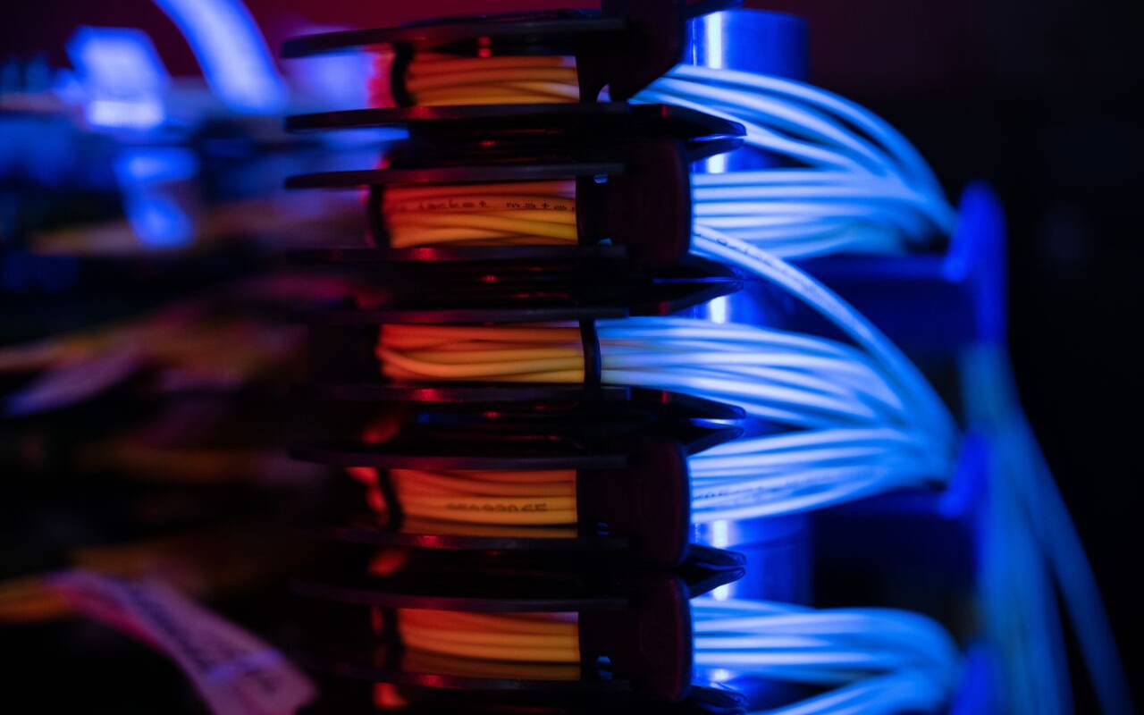 Glasfaserbündel liegen in einem Serverschrank.