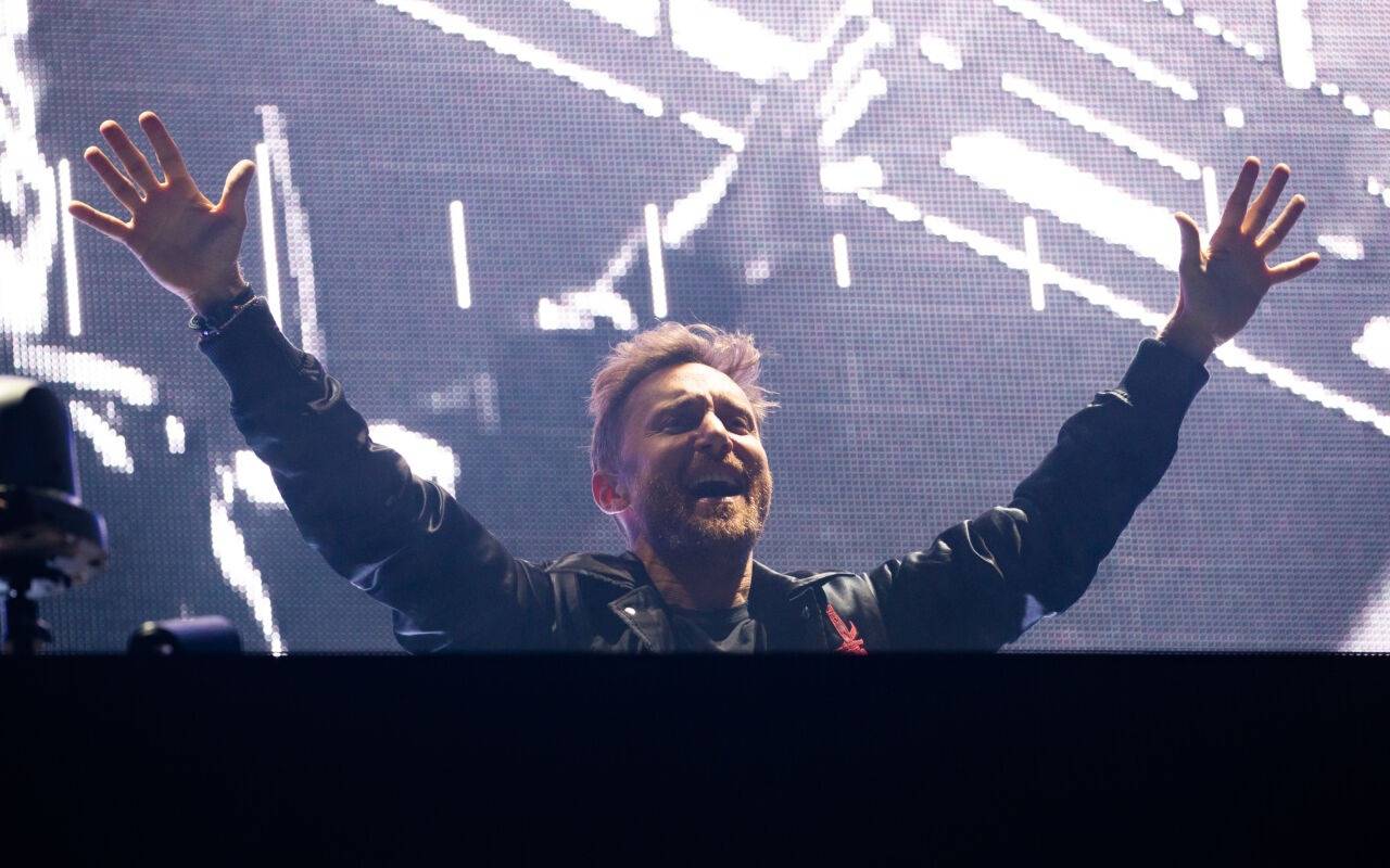 DJ David Guetta steht bei seinem Konzert anlässlich der Taufe für die neue AIDAnova an der Meyer Werft mit ausgestreckten Armen feiernd auf der Bühne.