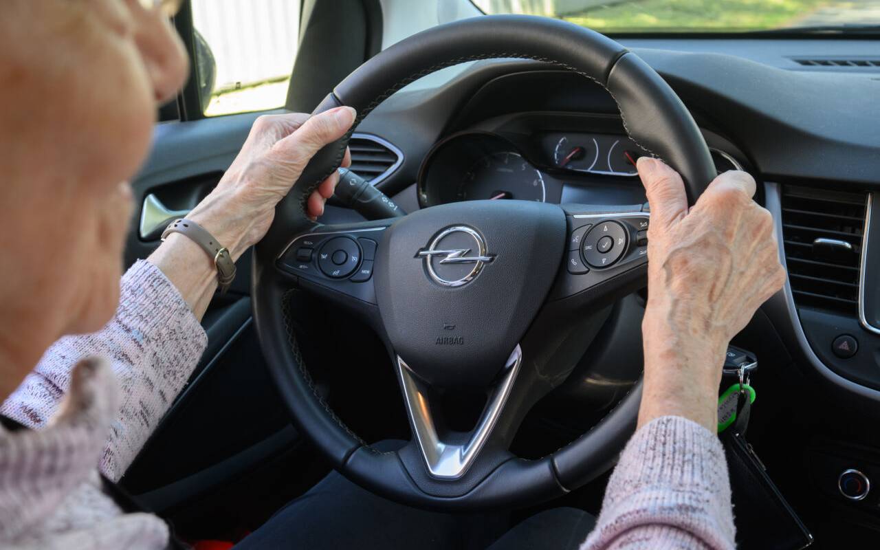 Eine ältere Autofahrerin sitzt am Steuer.