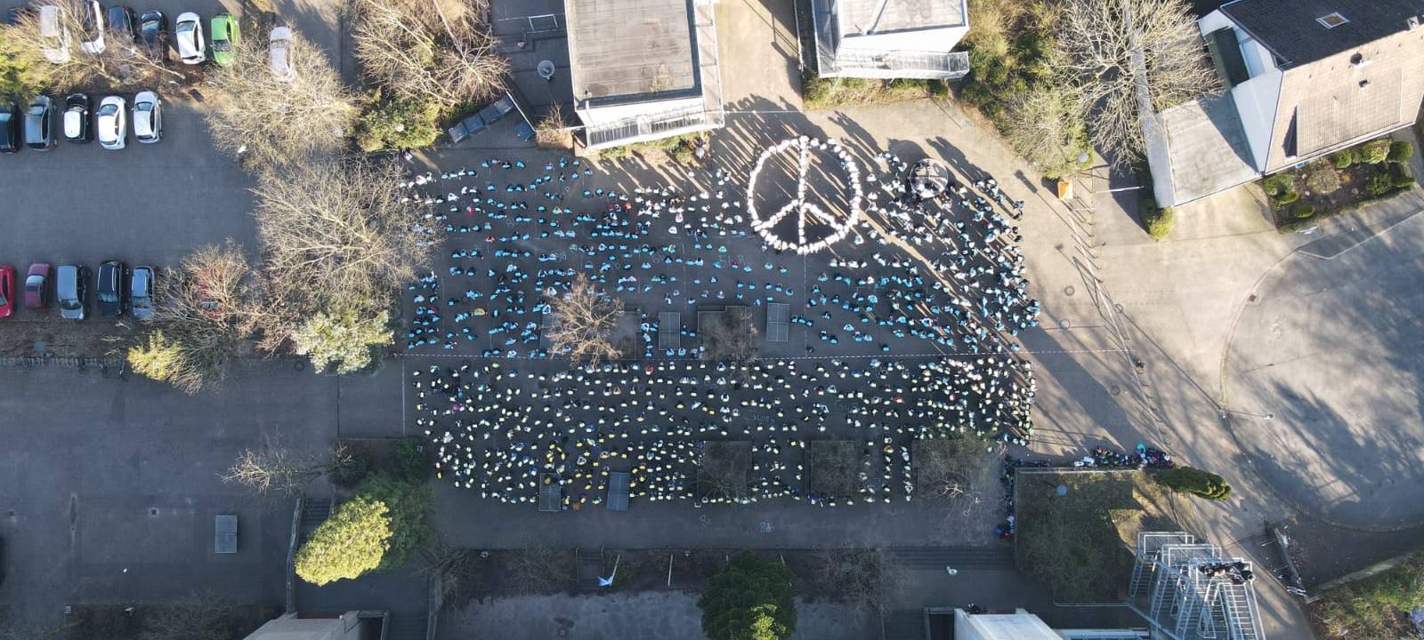 Friedensaktionen: Schüler bilden Peace-Zeichen