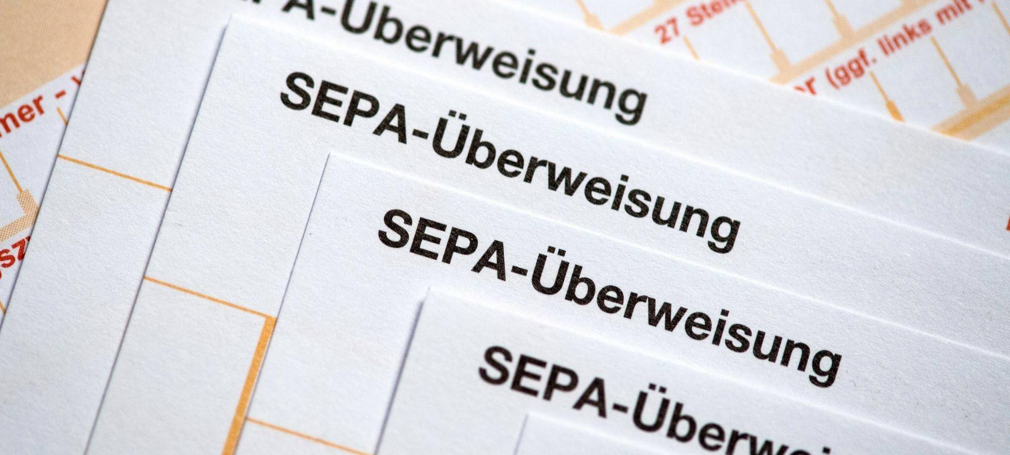 SEPA-Überweisungsscheine liegen auf einem Tisch